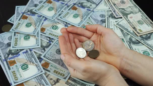 Mince padají do rukou na pozadí peněz se stovkou amerických dolarů bankovek — Stock video