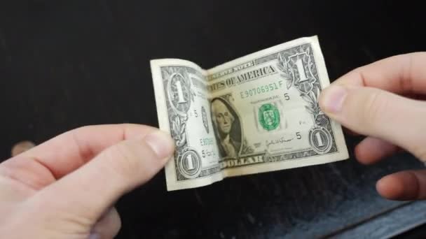 Мужские руки держат банкноту в 1 доллар США. Бедность и финансовый кризис — стоковое видео