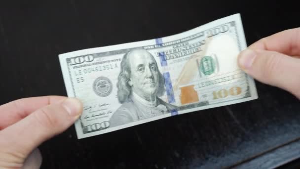 La personne tient dans ses mains un billet de cent dollars américains. Économie mondiale — Video