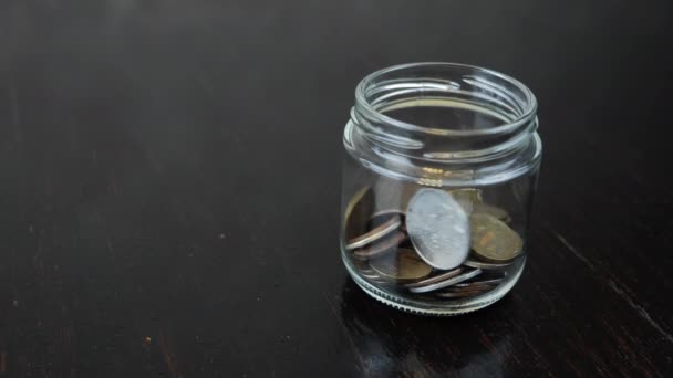 ガラス瓶にコインを入れ、閉じます。お金の概念を救う。世界経済 — ストック動画