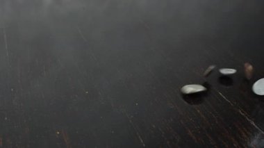 Cam kavanoz para kutusundan para yığını masaya düşüyor. Bozukluklar dökülüyor.