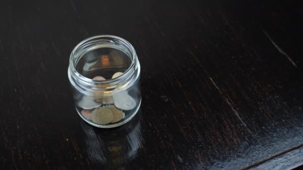 硬币掉进桌子上的玻璃瓶里了.世界经济。A.金融危机 — 图库视频影像