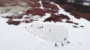 Kırsal alanda buz pateni yapan insanlar donmuş gölde