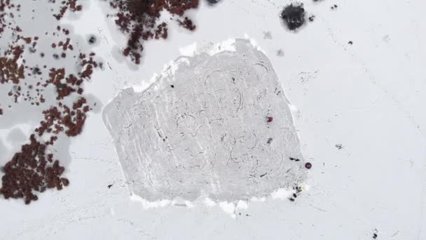 Люди катаються на ковзанах на морозильному льодовиковому озері з видом зверху — стокове відео