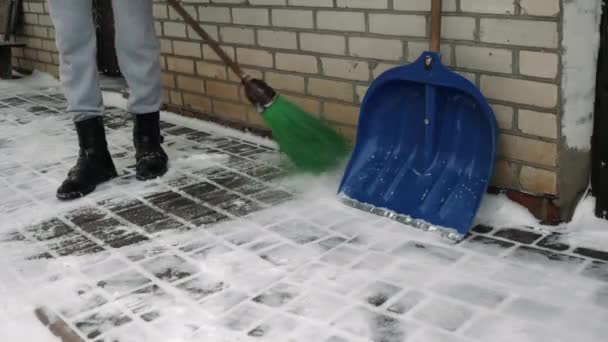 Hombre con escoba está limpiando la nieve en el patio trasero después de la tormenta de invierno — Vídeos de Stock