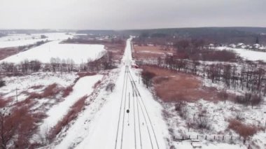 Kışın boş demiryolu rayları. İnsansız hava aracı tren istasyonunda demiryolu ile uçuyor.