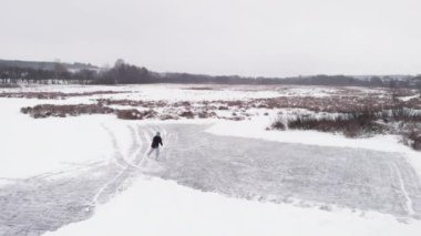 Buzlu gölde buz pateni yapan insan.