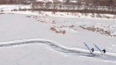 Donmuş gölde aile buz pateni. Erkek ve kadın gölette parkta buz pateni yapıyorlar.