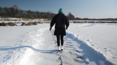 Kadın sadece donmuş gölde buz pateni yapıyor.
