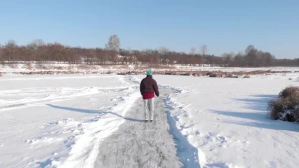 女は池でスケートをしている。凍った湖の上のスケートに女性が乗る — ストック動画