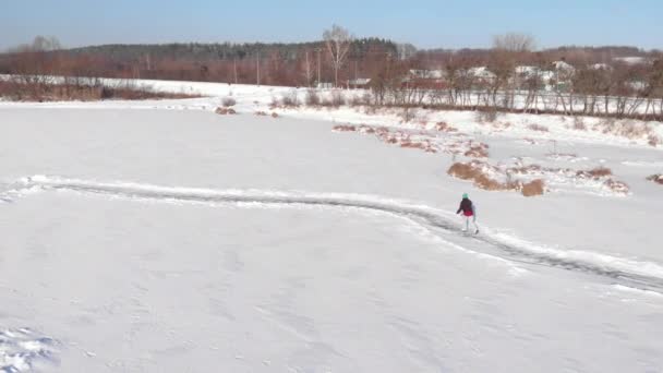 Женщина катается на коньках по замерзшему пруду зимой замерзает солнечный день — стоковое видео
