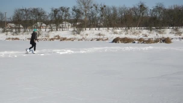 Patinaje sobre hielo en el lago congelado. Actividades al aire libre de invierno. Mujer patina en estanque congelado — Vídeos de Stock