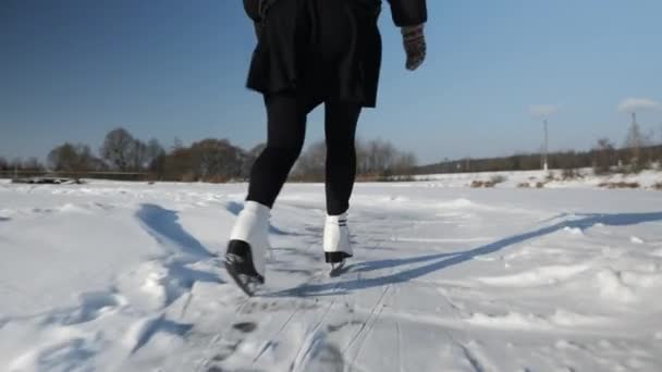 湖で冬のアイススケート。白いフィギュアスケートの女性の足オンアイス — ストック動画