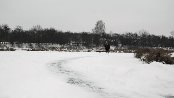 Patinação no gelo no lago congelado. Mulher na figura branca patina passeios em lagoa congelada — Vídeo de Stock