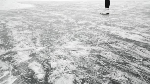 Vrouw benen in schaatsen schaatsen op bevroren meer. Vrouw glijdt op dik ijs — Stockvideo
