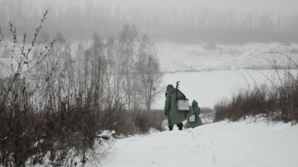 Fishermen are going to fishing on frozen lake. Concept of winter fishing — Stock Video