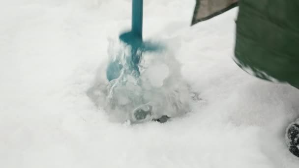 Le pêcheur perce un trou de glace sur l'étang. Trou sur un lac gelé percé avec une perceuse à glace — Video