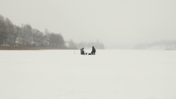 Οι ψαράδες πιάνουν ψάρια στην παγωμένη λίμνη. Έννοια της χειμερινής αλιείας — Αρχείο Βίντεο