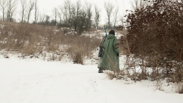 Uomo alla pesca invernale. Pescatore sta andando al lago ghiacciato per catturare il pesce in buca di ghiaccio — Video Stock