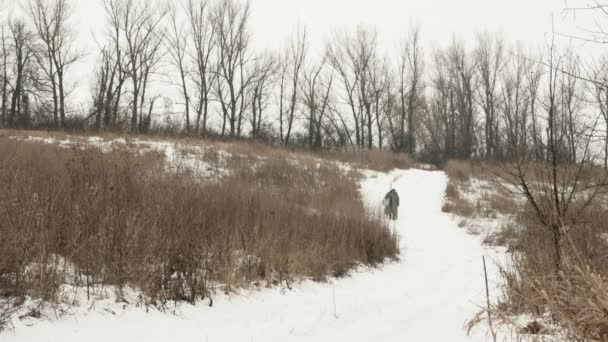 Pescador está andando na neve através de juncos de pesca de inverno — Vídeo de Stock