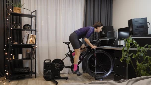 Ciclista está pedalando rápido no treinador de bicicleta inteligente. Ciclismo interno. Conceito de aptidão — Vídeo de Stock