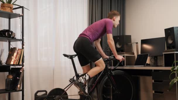 Homem está girando pedais no interior inteligente bicicleta treinador. Ciclismo Indoor — Vídeo de Stock