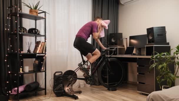 인간은 움직이지 않는 스마트 자전거 조련사를 타고 있습니다. 실내 자전거타기. 건강 활동 — 비디오