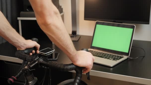 Mãos masculinas estão segurando guidão de ciclismo, mudando de engrenagem em bicicleta estacionária em casa — Vídeo de Stock