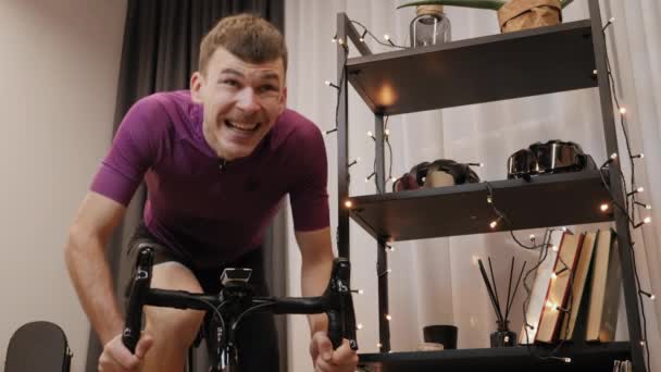 Ciclista profesional se está quedando sin silla de montar en bicicleta inteligente estacionaria entrenador — Vídeos de Stock