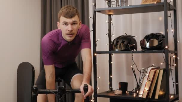 Mann trinkt Wasser nach hartem Ausdauertraining auf Indoor-Smart-Trainer