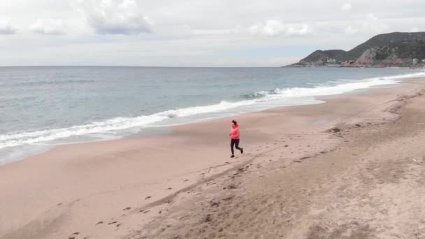 アクティブスポーツ。若い女性は砂浜を走る。コンセプトの実行 — ストック動画