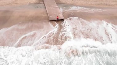 Yalnızlık ve özgürlük kavramı. Soğuk rüzgarlı bir günde yalnız bir insan iskelenin kenarında oturuyor.