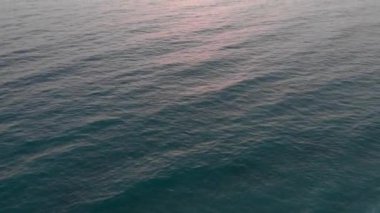 Denizde gün batımı, suda yansıyan güneş ışığı. Pembe okyanus gün batımı