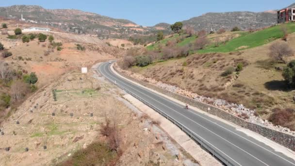 Woman is cycling on road bicycle alone. Female is pedaling on bike in highlands — Stock Video