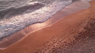 Denizde renkli bir gün batımı. Deniz dalgaları ve günbatımı plajı. Gün batımında parlayan altın dalgalar