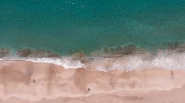 Okyanus mavisi dalgalar kumlu sahilde kırılır. Deniz dalgaları ve güzel tropikal kumsal