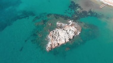 Yukarıdan deniz ve uçurum. Şiddetli dalgalar okyanustaki kayalıklara çarpıyor.