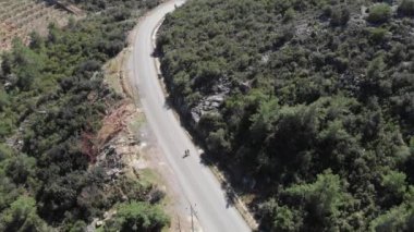 Bisikletçi bisikletle dağdan aşağı iniyor. Sporcu bisiklet sürüyor.