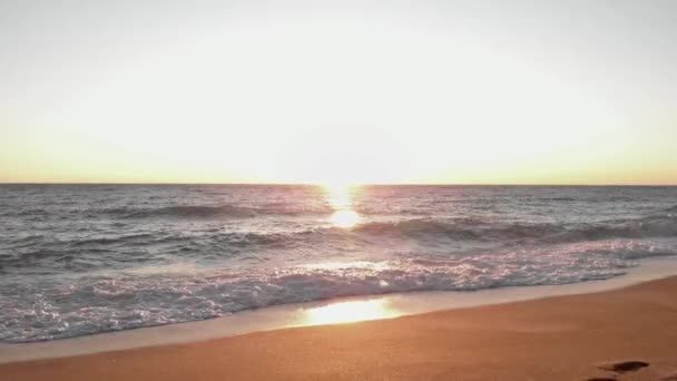 Θαλασσινά κύματα πέφτουν και συντρίβονται στην παραλία το ηλιοβασίλεμα. Ήλιος ωκεανού πάνω από την επιφάνεια — Αρχείο Βίντεο