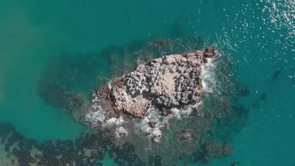 Eau de mer turquoise claire avec falaise rocheuse en pierre. falaise rocheuse vide dans la mer avec des vagues s'écrasant sur les rochers — Video