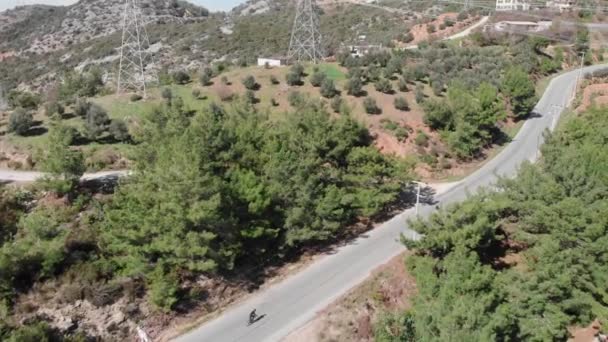 Triatleta está subiendo al paso de montaña en bicicleta de carretera en carretera vacía — Vídeos de Stock