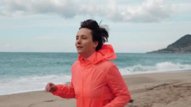 Sportif güdümlü genç bir kadın sahilde koşuyor. Kadın sahilde koşuyor.