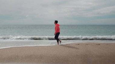 Özgürlük ve mutluluk kavramı. Kadın boş deniz kıyısında yürüyor.