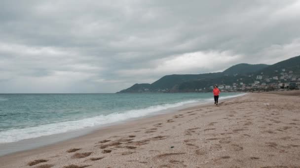 Mujer fitness está haciendo ejercicio al aire libre, corriendo en la playa con el fondo del paisaje marino — Vídeos de Stock