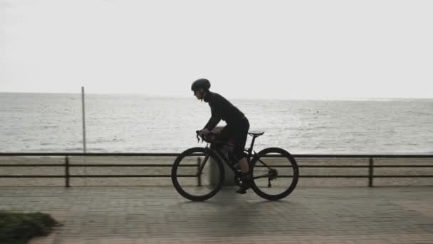 Kvinnlig cyklist är hårt trampande på cykel på promenaden. Kvinnan cyklar på cykel — Stockvideo