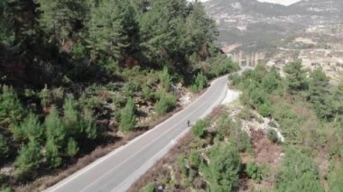 Kadın bisikletçi dışarıda bisiklet eğitimi alıyor. Formda bir kadın bisikletle dağlarda dolaşıyor.