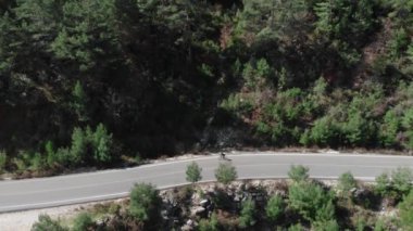 Profesyonel bisikletçi ormanda boş bir yolda bisiklet sürüyor. Açık hava bisikleti