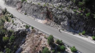 Bisikletçi ormanda dağ yolunda bisiklet sürüyor. Kadın bisiklete biniyor.
