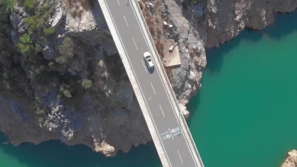 L'auto sta guidando su strada di auto vuota attraverso il fiume. Paesaggio montano con lago e scogliere — Video Stock