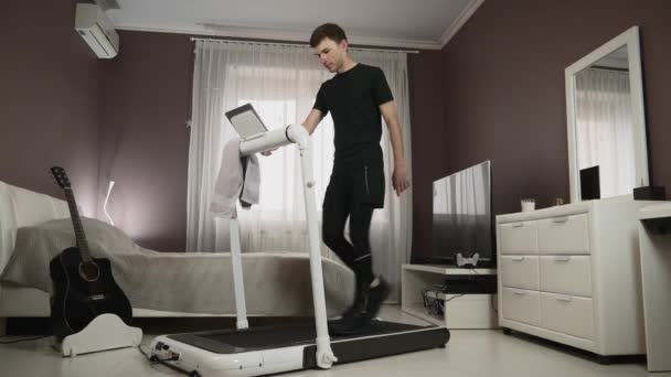 Athlete is running on treadmill at home. Man is training on running machine — Stock Video